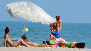 Filles nues à la plage au soleil attendent massage